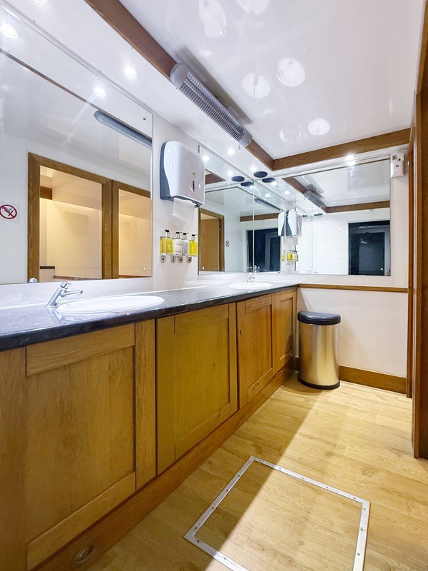 Toilet trailer with white walls and wood trim