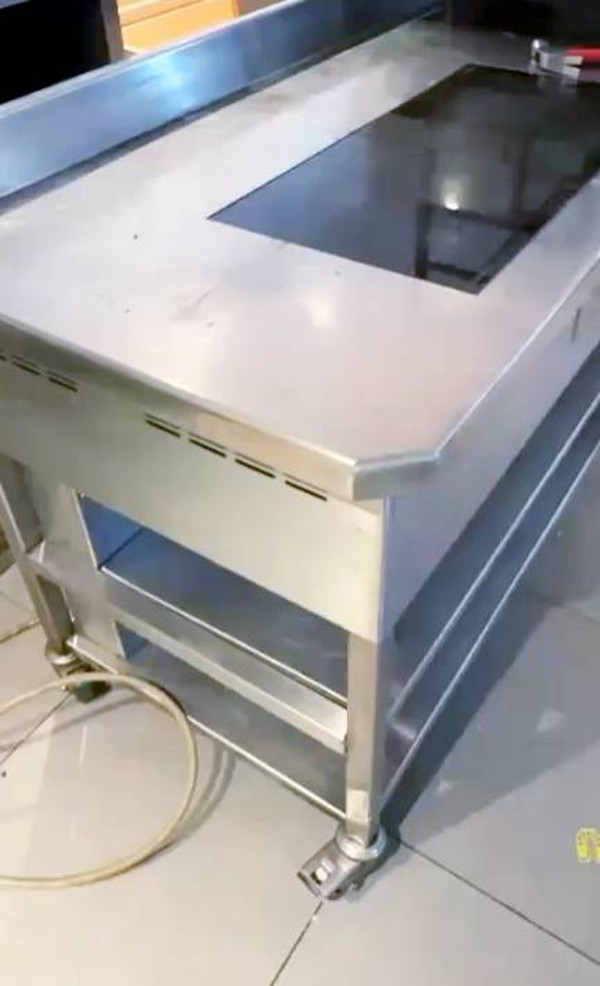 Induction cooker mounted in stainless steel table Induction cooker mounted in stainless steel table