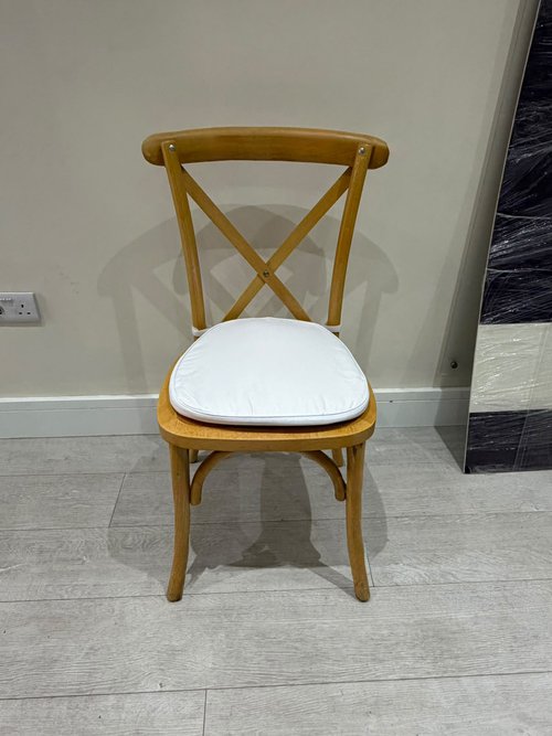 Cross back banqueting chairs with white seat pad.