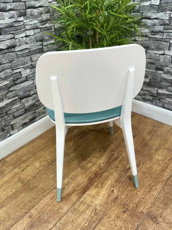 White chair with green leather seat pads