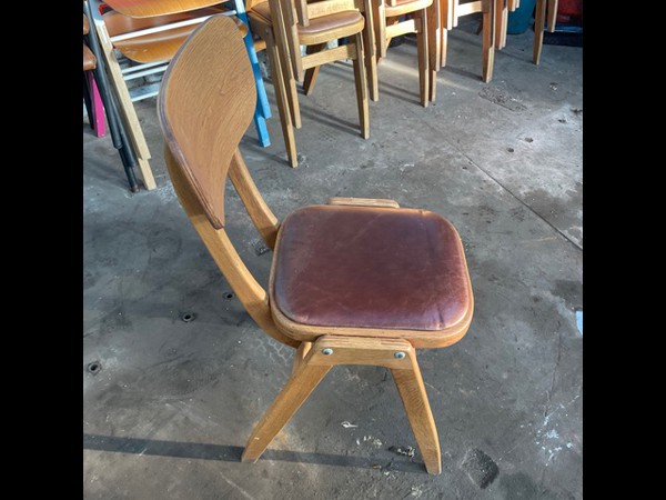 Used stacking wooden chairs with leather seat pads