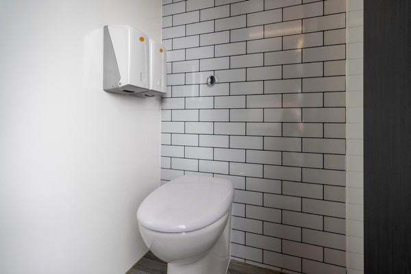 Toilet trailer cubicle with brick tiles