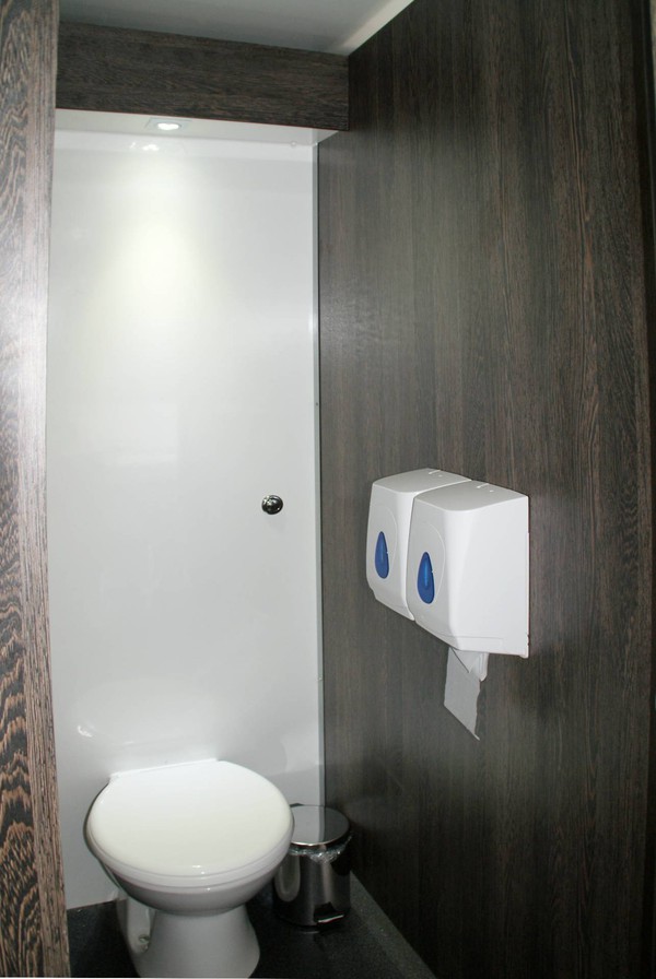 Toilet cubicle with dark wood trim