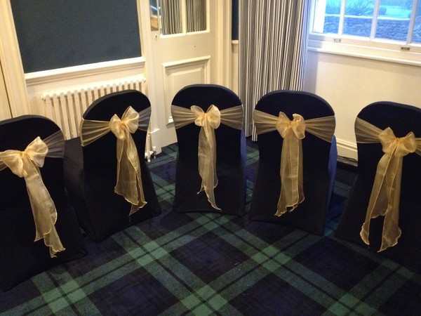 Black chair covers with gold bows