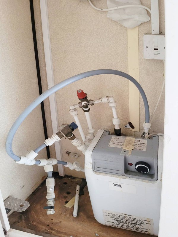 Service cupboard with hot water heating