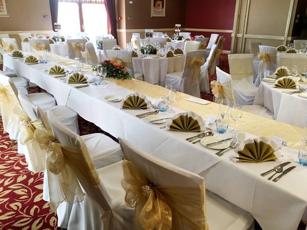 White chairs covers with gold bows