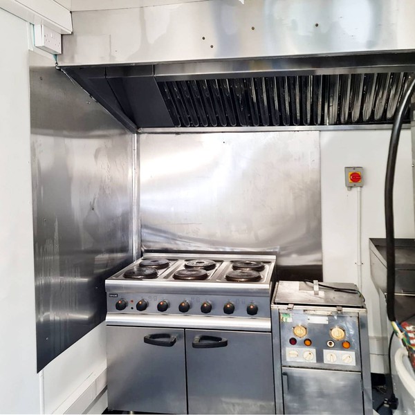 Six burner cooker and fryer under an extraction hood