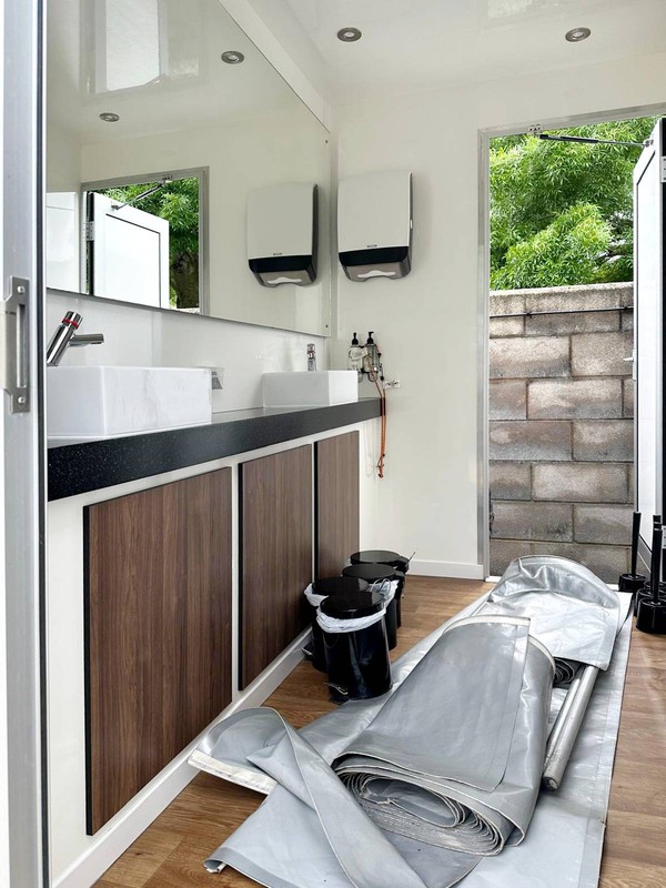 Grey toilet trailer with skirts
