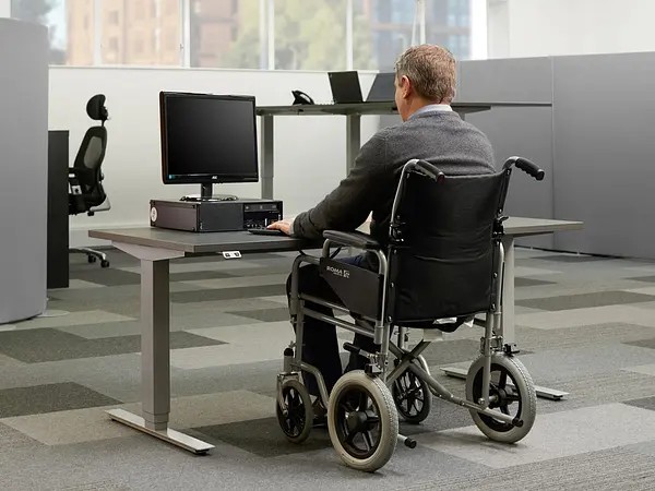 Height adjustable desk for wheel chair users