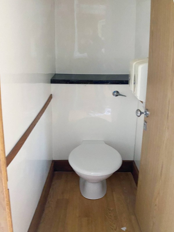 Toilet trailer with clean white interior and wooden trim