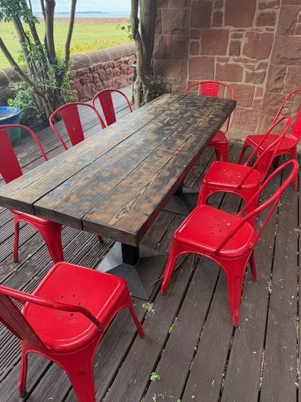 Rustic wooden tables and red Tolix chairs for sale